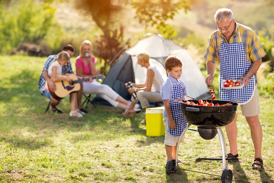 Generation family cooking on grill on camping
