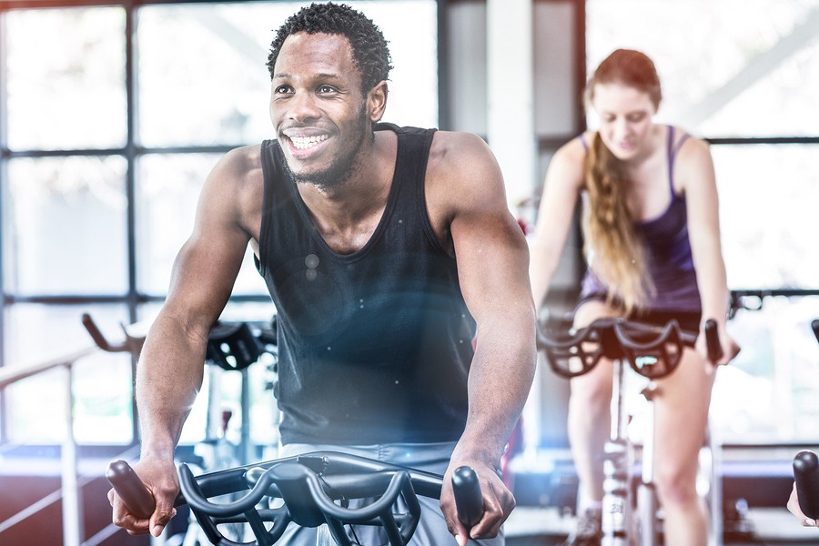 Fit man working out at spinning class in gym