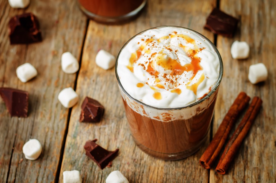 Dark Hot Chocolate With Whipped Cream And Salted Caramel Sauce On A Wood Background