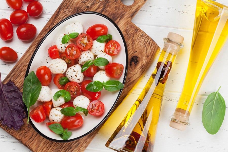 Caprese salad with mozzarella, cherry tomatoes and fresh garden basil. Top view